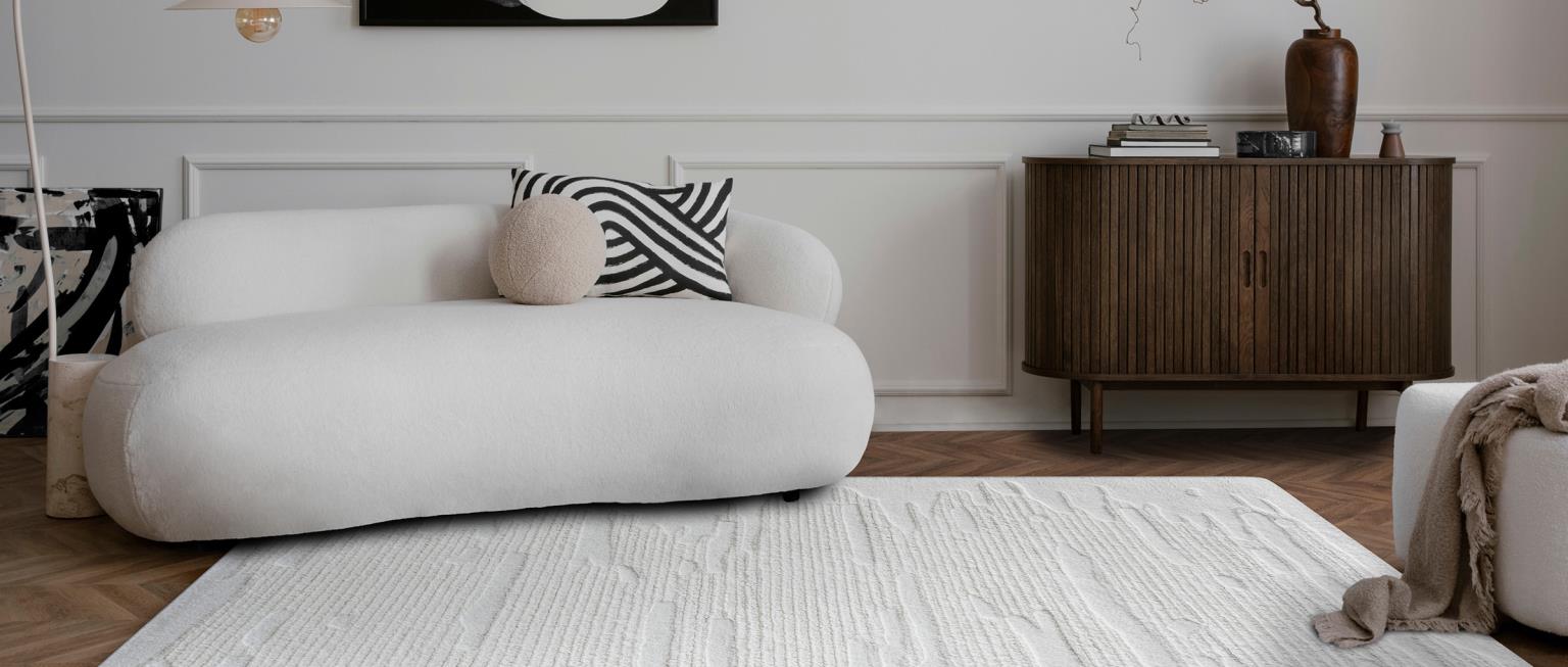 Midcentury leather sopha with low pile muted geometic rug